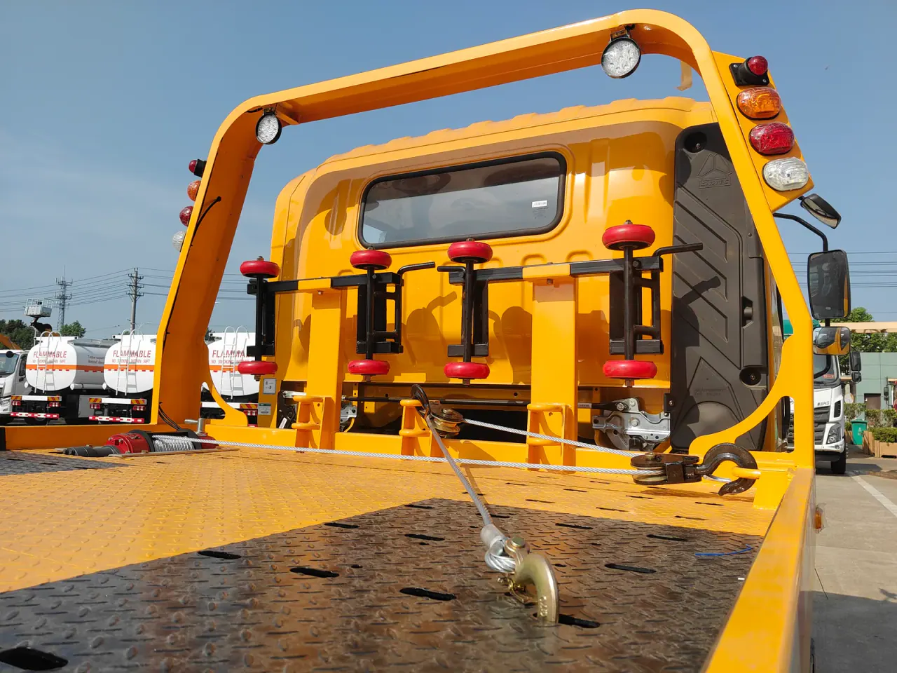 Steel winch cable, hook, guide pulleys, work lights, and wheel dollies behind the cab