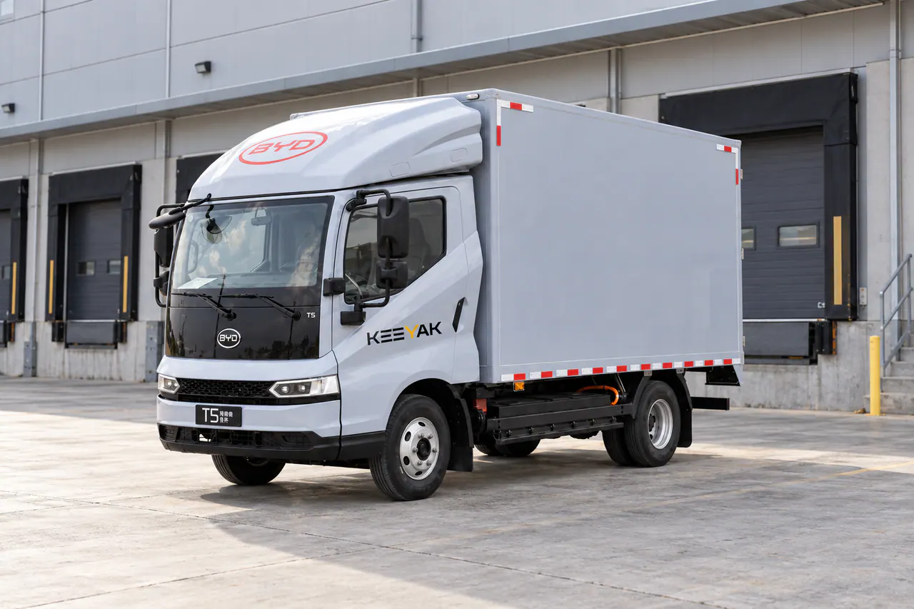 Gray, black and red electric van truck viewed from the front left