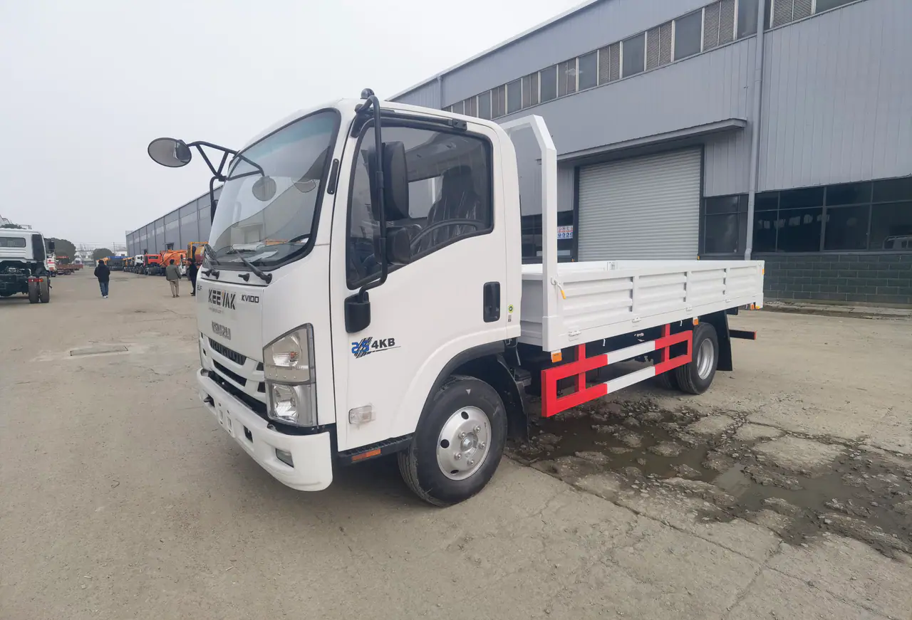 Camion plateau ISUZU KV100 blanc dans la cour de l'usine