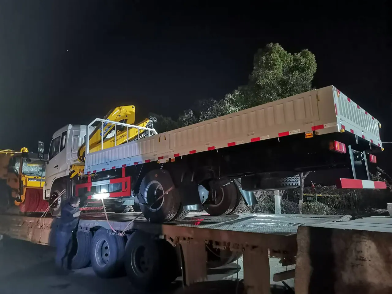 Side photograph of a real truck-mounted crane during transport preparation