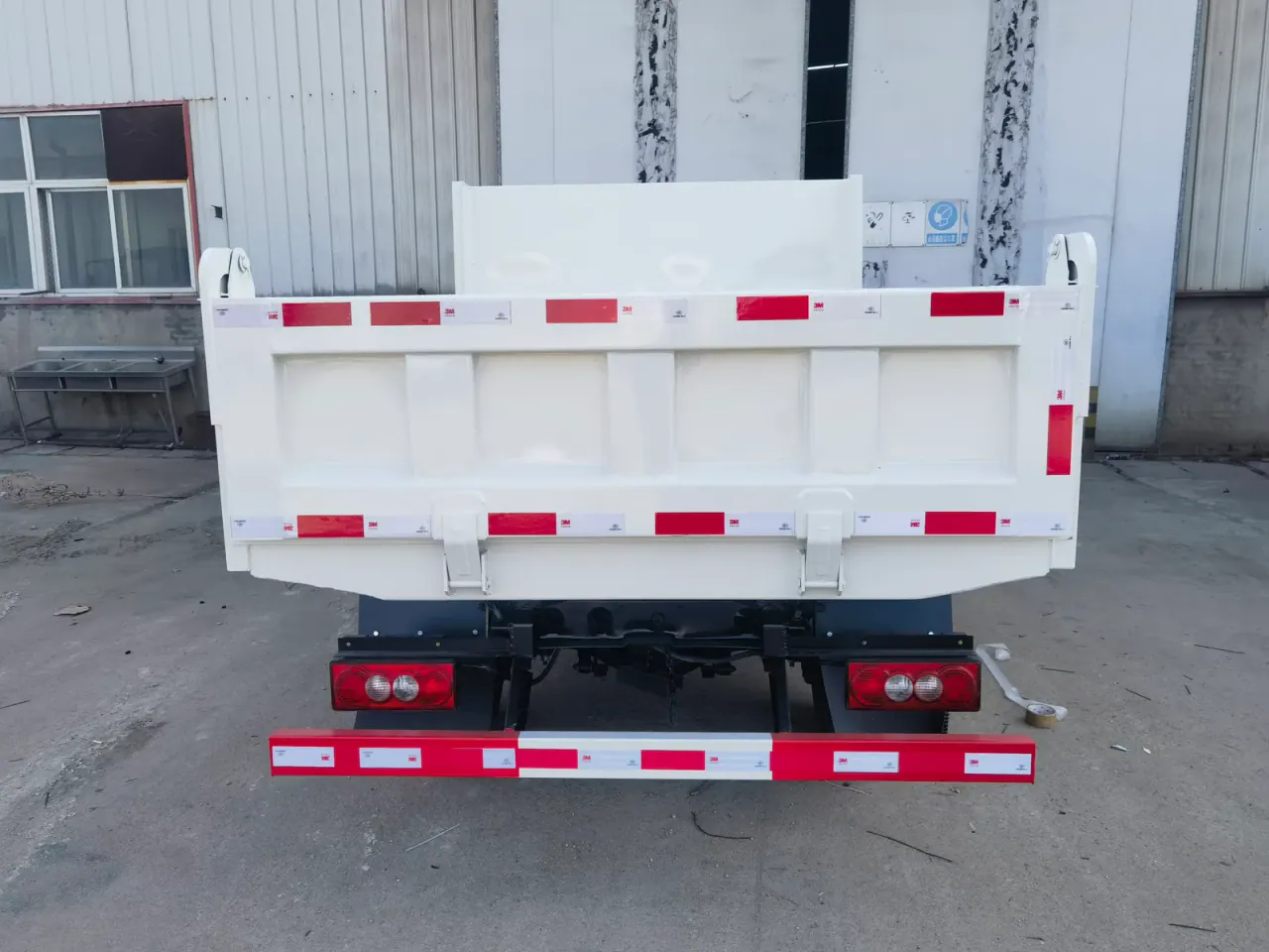 Rear tailgate, hinges and frame of a white dump body