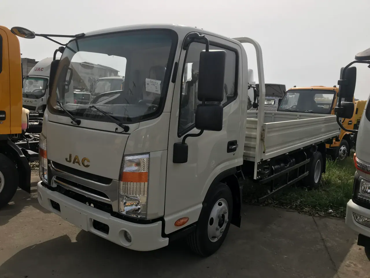 White JAC single-cab drop-side truck viewed from the front left