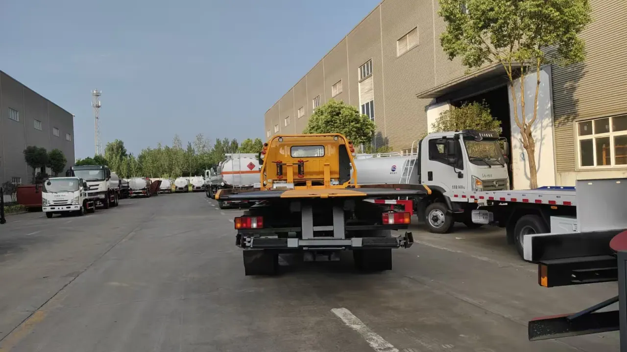 Rear view of a flatbed recovery truck with tail lamps and loading structure