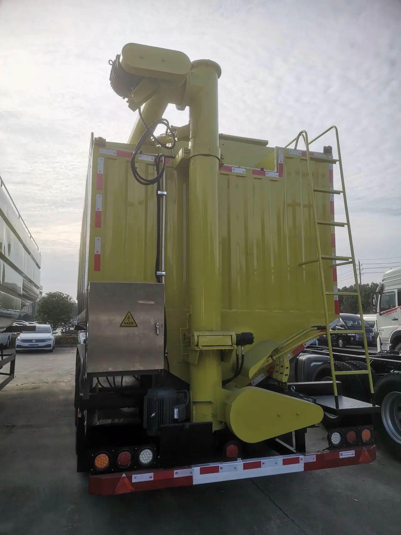 Folded discharge boom above the rear of the feed trailer