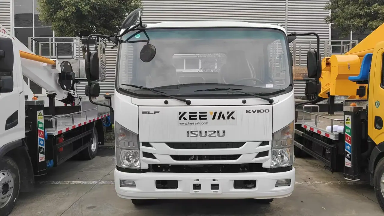 Front of a white ISUZU KV100 truck between other platform vehicles