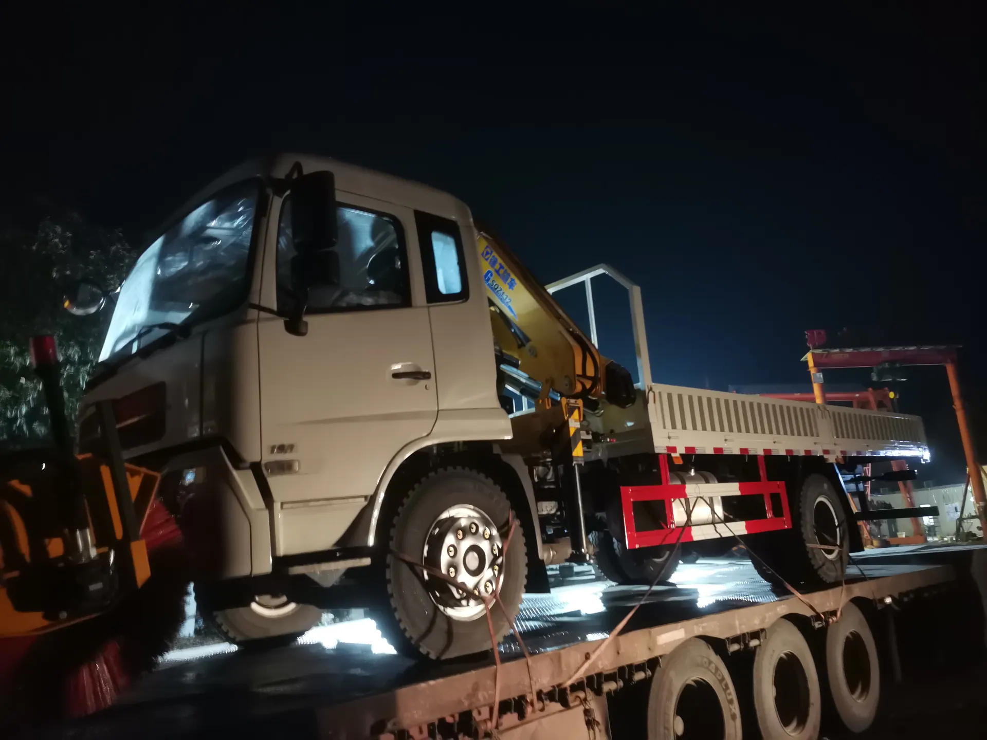 Rear-side photograph of a real truck-mounted crane during loading