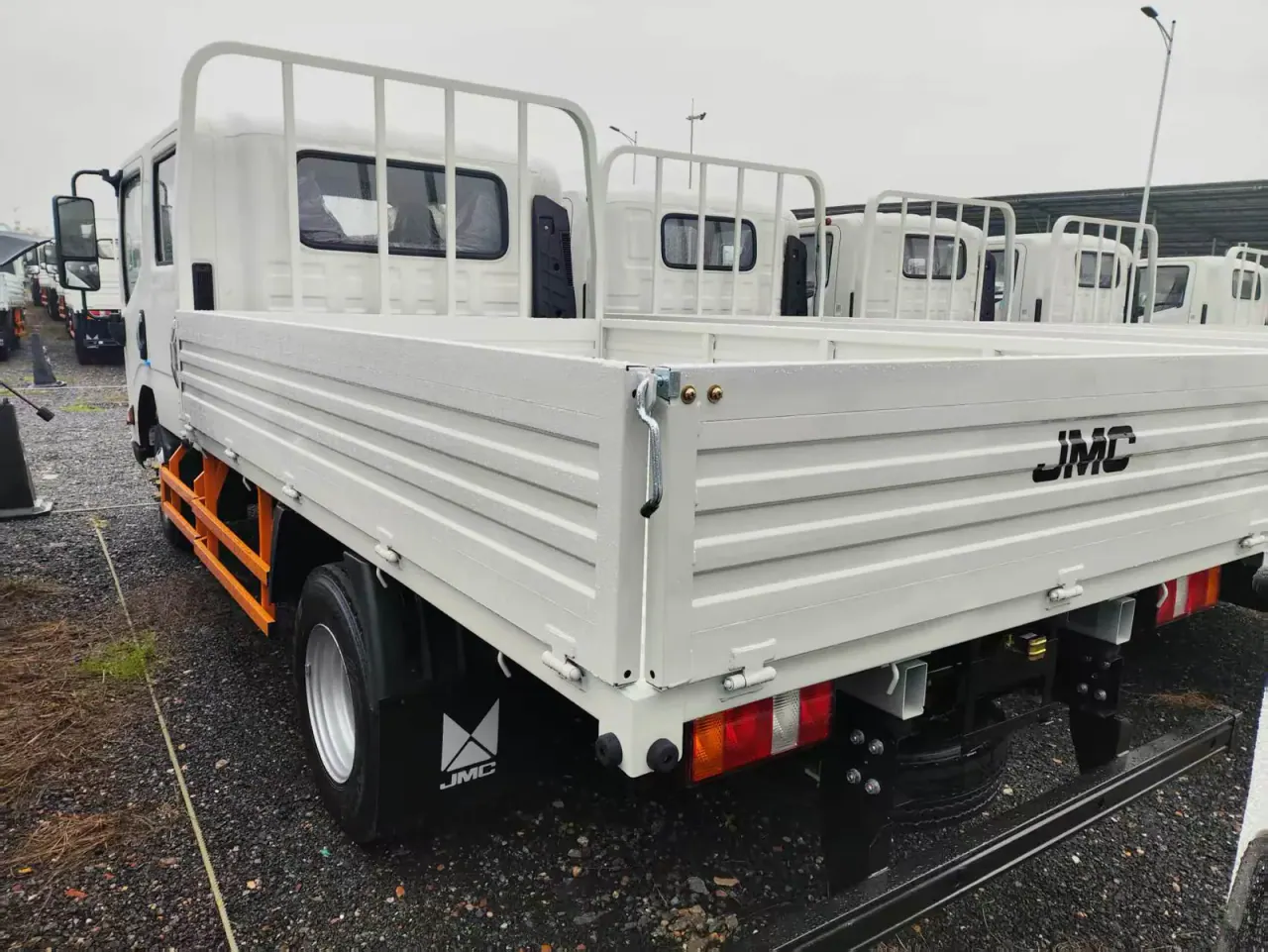 Côté et arrière d'un camion blanc avec panneaux de chargement à charnières basses