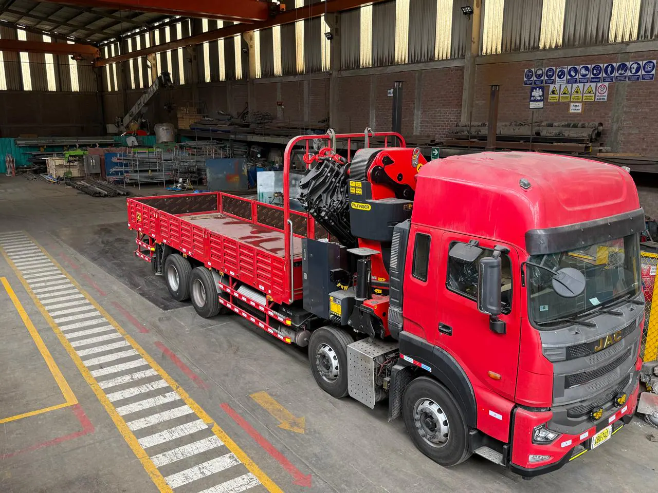 High-angle factory view of the red JAC 8x4 crane truck