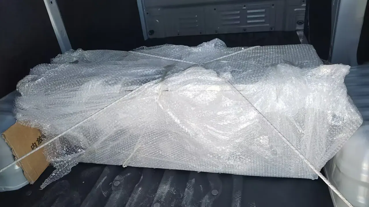 Close view of a bubble-wrapped item secured inside a cargo van