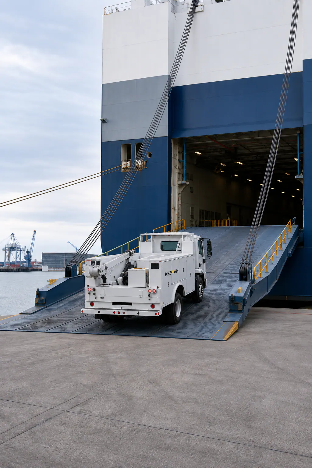 Complete utility truck driving onto a roll-on roll-off cargo vessel