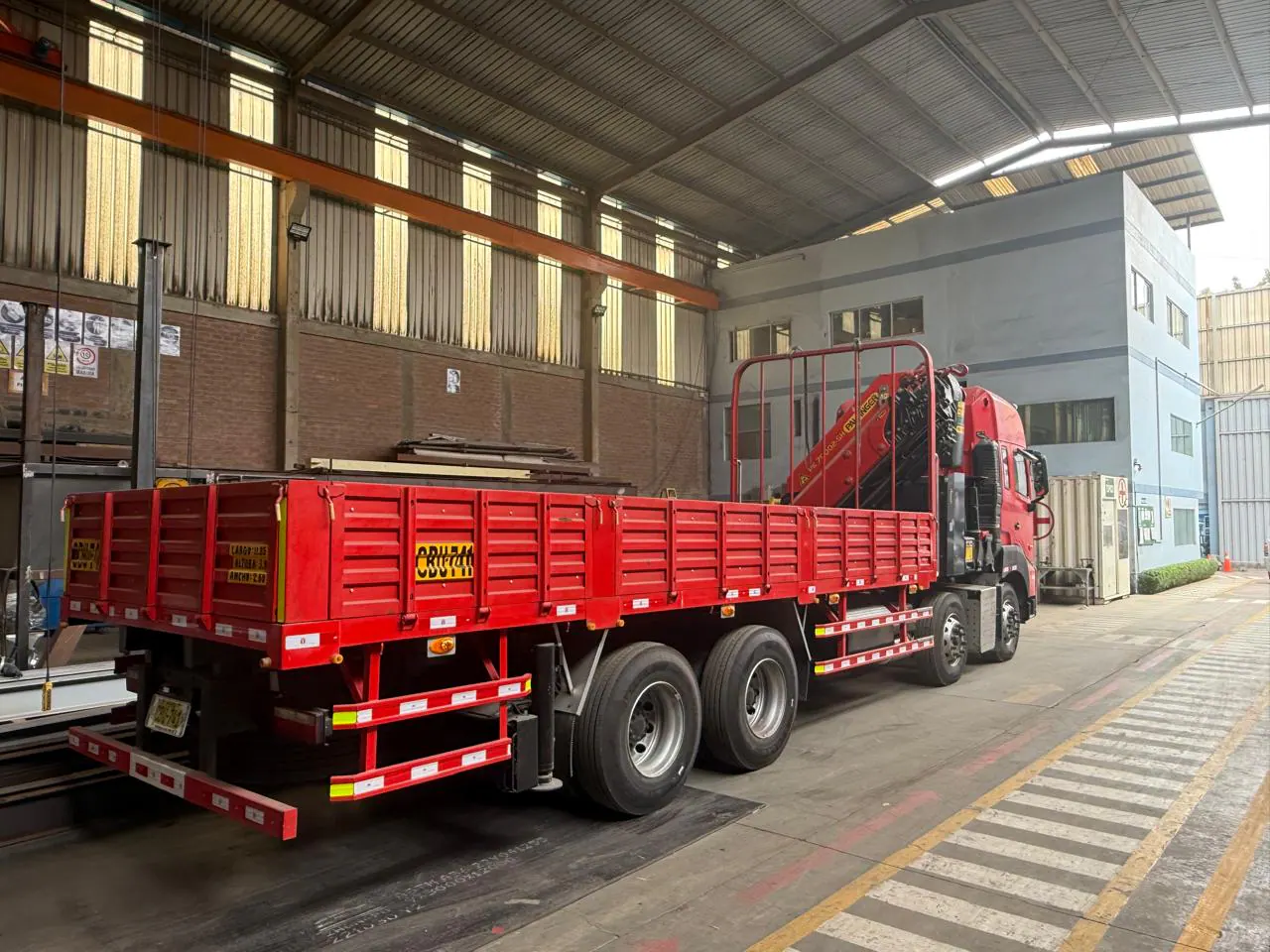 Rear three-quarter factory view of the red JAC 8x4 crane truck