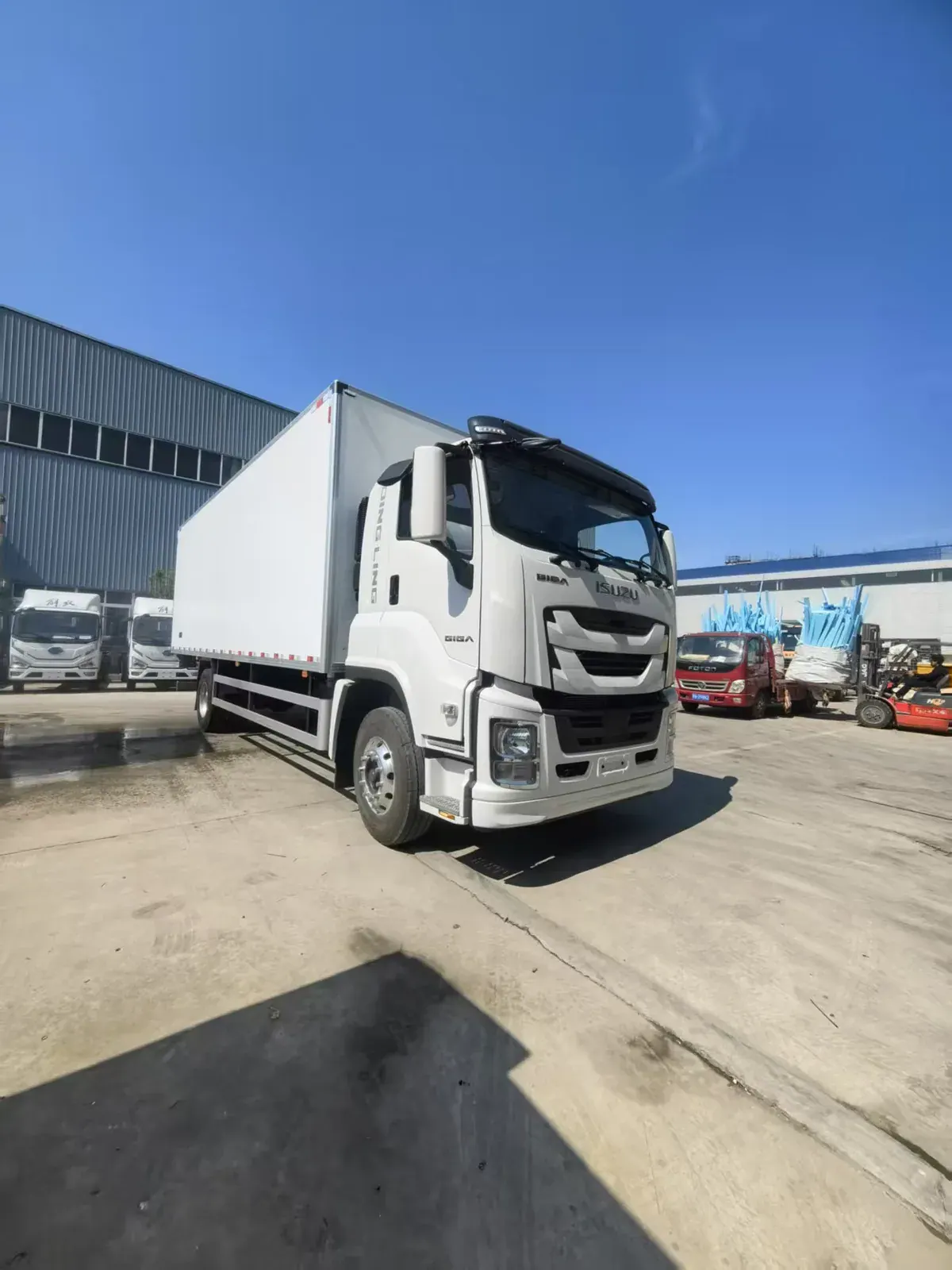 White ISUZU truck with GIGA badges and an enclosed cargo body